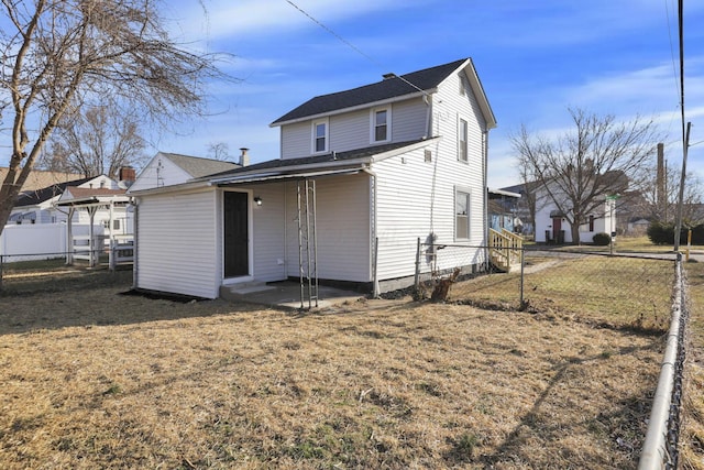 rear view of property with a lawn and fence