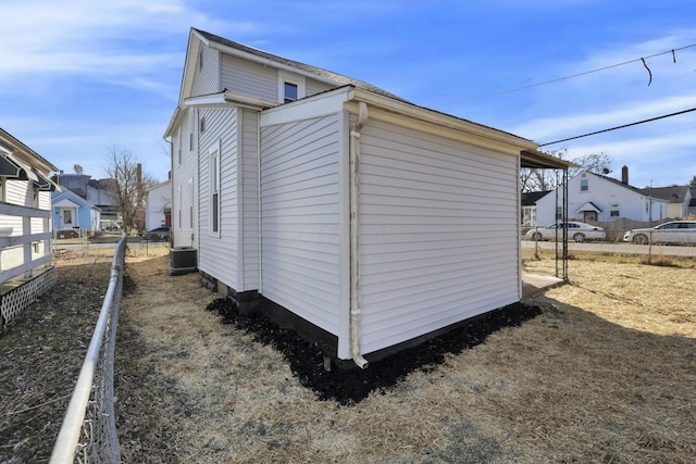 view of property exterior featuring fence and a residential view