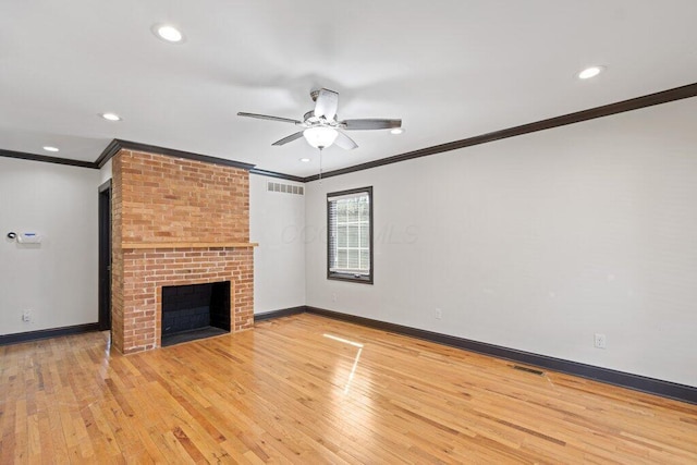 unfurnished living room featuring visible vents, light wood-style floors, ornamental molding, and a fireplace