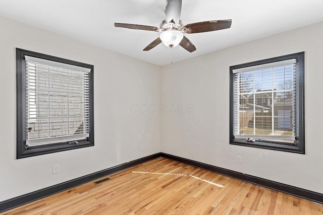 unfurnished room featuring visible vents, baseboards, light wood finished floors, and ceiling fan