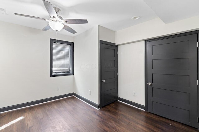 unfurnished bedroom featuring ceiling fan, visible vents, baseboards, and dark wood-style floors