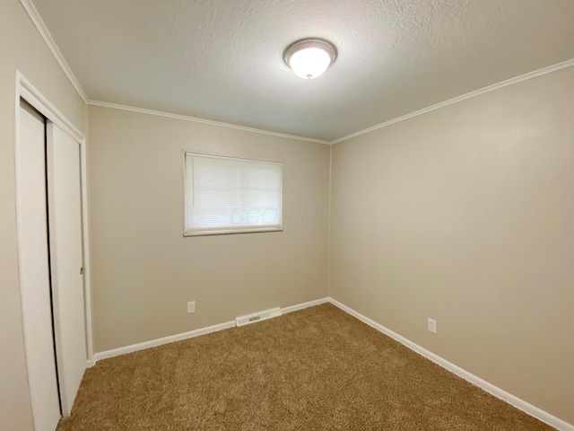 1309 Shanley Dr, Columbus, OH 43224 - unfurnished bedroom featuring carpet flooring, a closet, baseboards, crown molding, and a textured ceiling