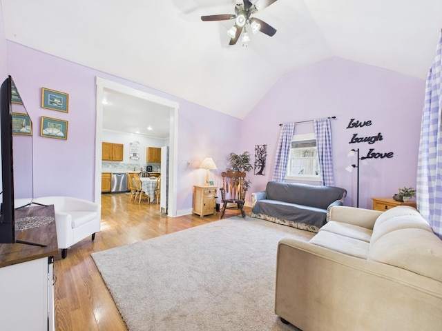 living area with light wood-type flooring, a ceiling fan, and vaulted ceiling