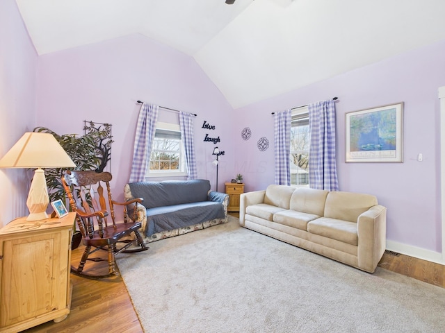 living area with lofted ceiling, wood finished floors, and baseboards