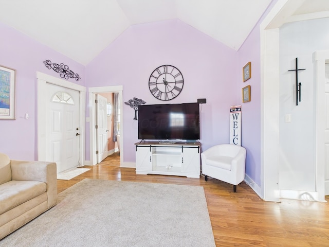 living room with baseboards, lofted ceiling, and wood finished floors