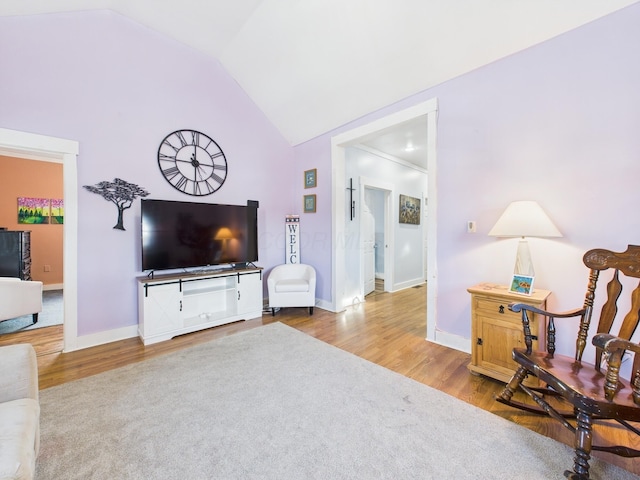 living room with vaulted ceiling, wood finished floors, and baseboards