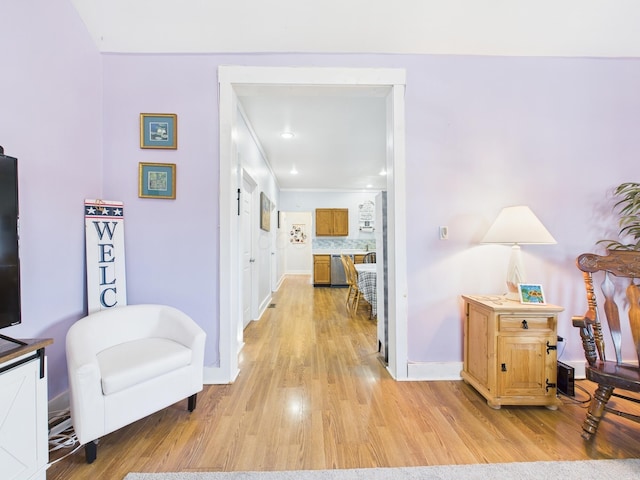 corridor with baseboards and light wood finished floors