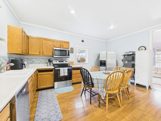 kitchen featuring light wood-type flooring, tasteful backsplash, appliances with stainless steel finishes, crown molding, and light countertops