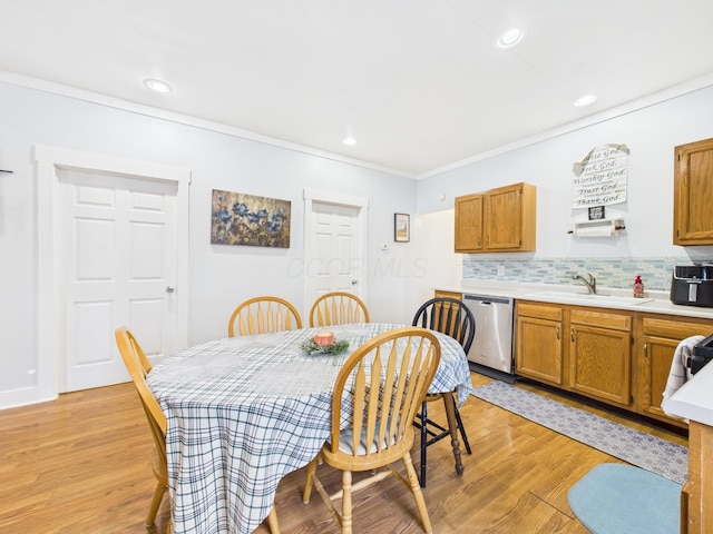 dining room featuring crown molding, recessed lighting, and light wood-style floors