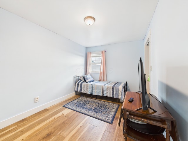 bedroom with baseboards and wood finished floors