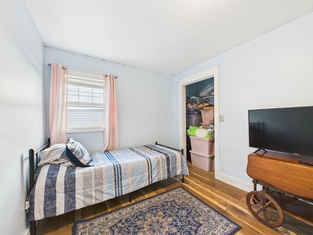 bedroom with baseboards and wood finished floors