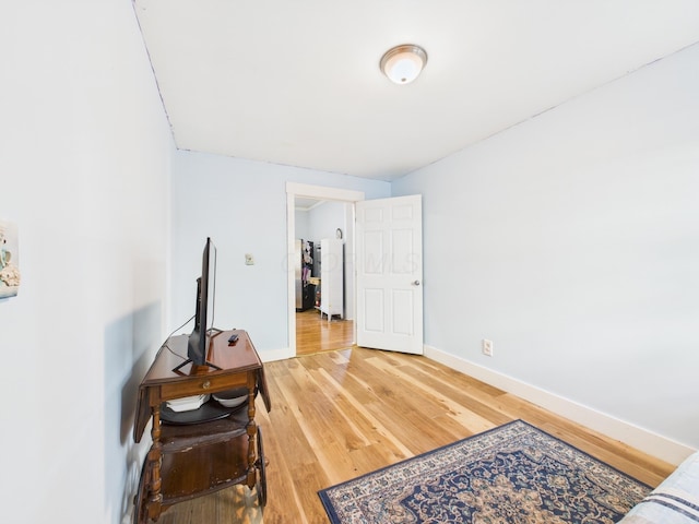 bedroom with baseboards and light wood finished floors