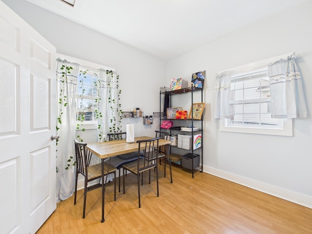 dining area with a wealth of natural light, baseboards, and wood finished floors