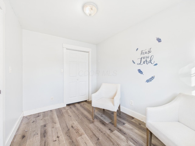 living area featuring light wood finished floors and baseboards