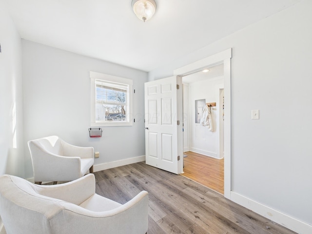 living area with baseboards and wood finished floors