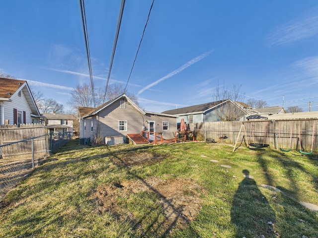 back of house featuring a lawn and a fenced backyard