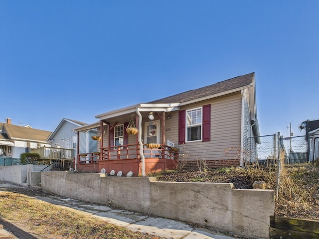 view of front of property with covered porch and fence