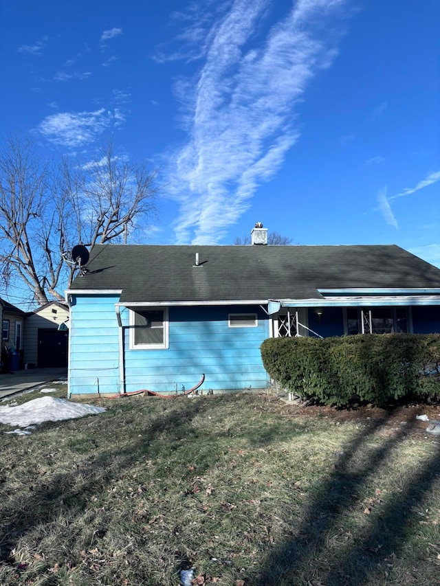 rear view of house featuring a yard