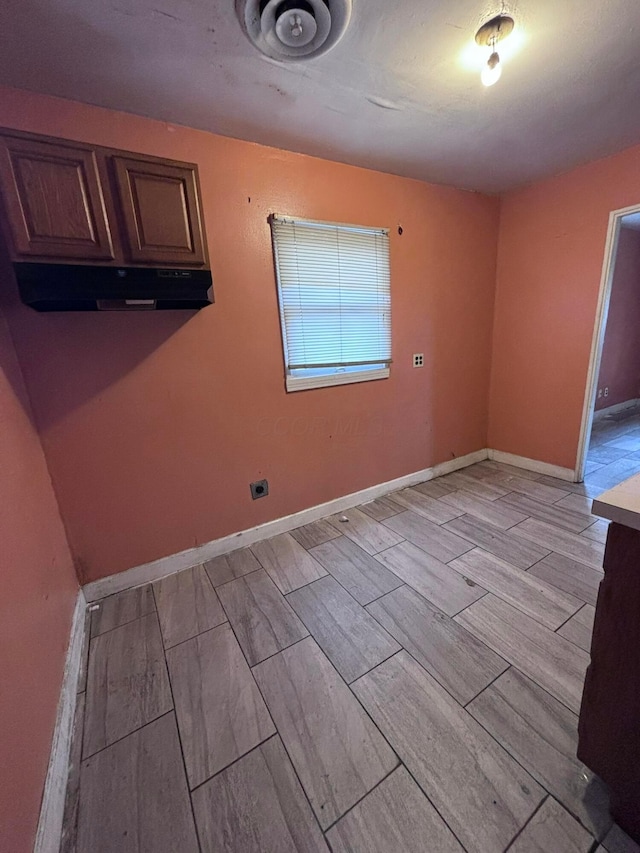 unfurnished room featuring baseboards and wood tiled floor