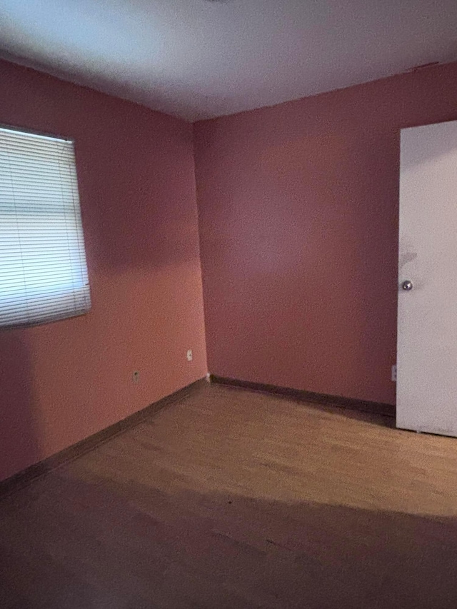 unfurnished room with wood finished floors and baseboards