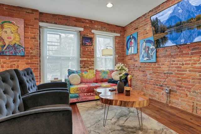 living room featuring wood finished floors and brick wall