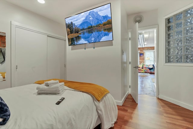 bedroom featuring wood finished floors, baseboards, and a closet