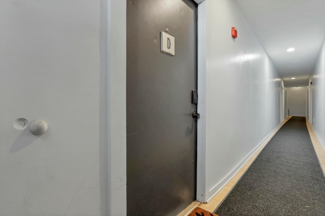 hallway with recessed lighting and baseboards