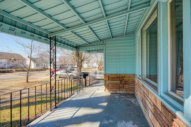 view of patio featuring a residential view, a carport, and fence