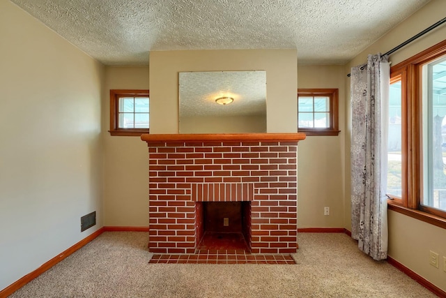 unfurnished living room with a brick fireplace, carpet, visible vents, and baseboards