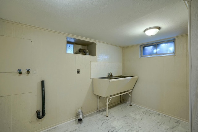 laundry room with electric dryer hookup, a textured ceiling, marble finish floor, and laundry area