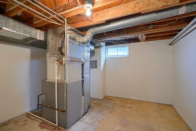 below grade area with baseboards and heating unit