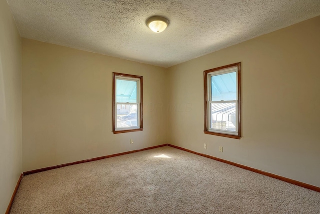 unfurnished room featuring carpet flooring, a textured ceiling, and baseboards