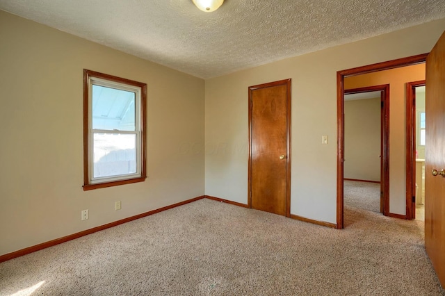 unfurnished bedroom with baseboards, a textured ceiling, and carpet