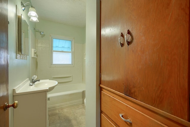 full bath featuring bathing tub / shower combination, vanity, and a textured ceiling