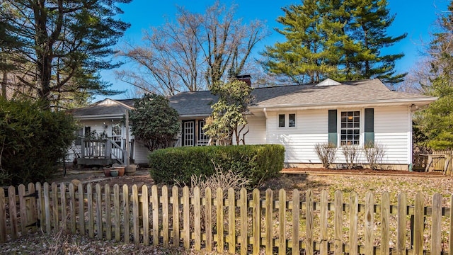 single story home featuring a fenced front yard, a chimney, and roof with shingles