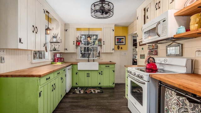 kitchen with a sink, wooden counters, dark wood-style flooring, white appliances, and green cabinetry