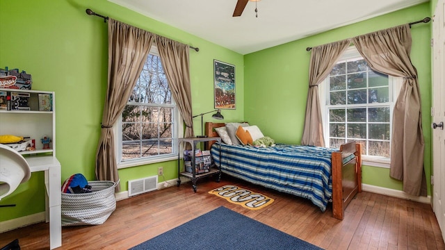 bedroom featuring visible vents, baseboards, and wood-type flooring