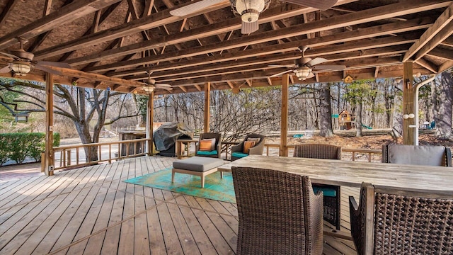 deck featuring outdoor dining space, area for grilling, and ceiling fan