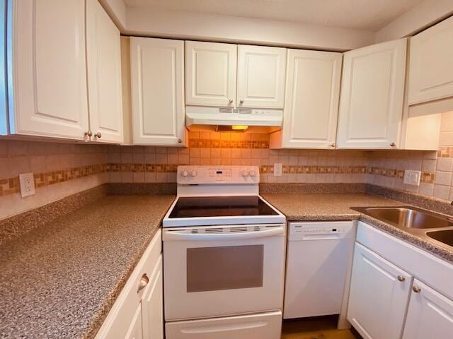 kitchen featuring under cabinet range hood, decorative backsplash, white appliances, and white cabinets