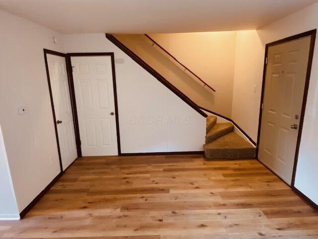 entryway with light wood-type flooring and stairs