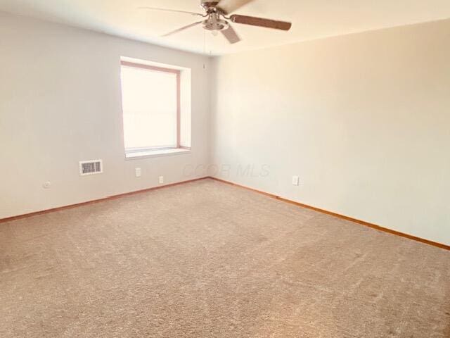 unfurnished room with baseboards, visible vents, carpet floors, and ceiling fan