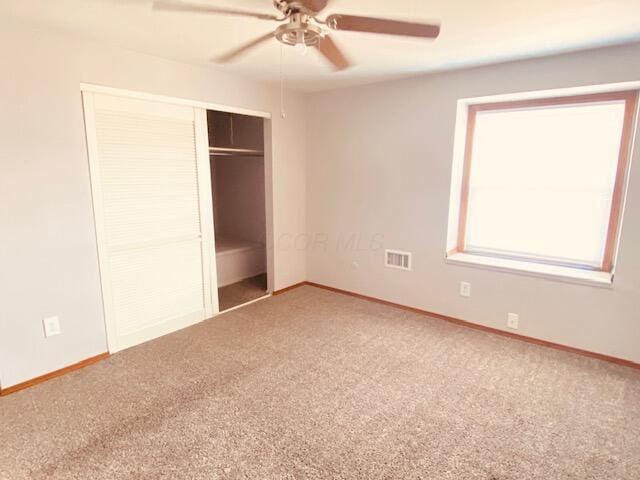 unfurnished bedroom with a ceiling fan, baseboards, visible vents, a closet, and carpet flooring