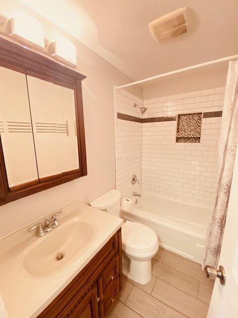 bathroom featuring vanity, visible vents, shower / tub combo, tile patterned floors, and toilet