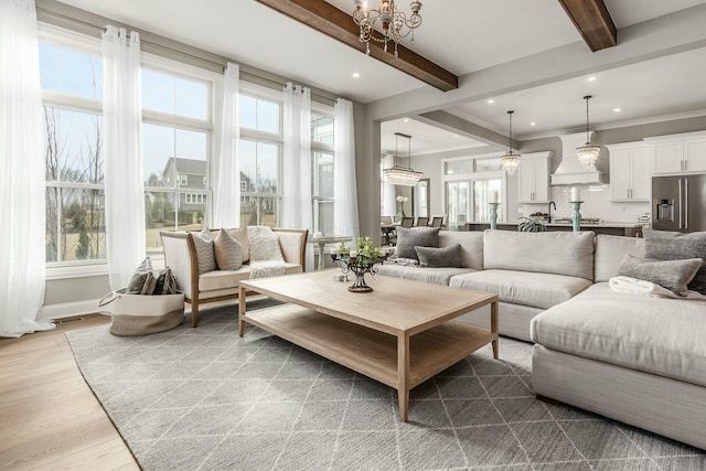 living area featuring beam ceiling, plenty of natural light, light wood-style flooring, and recessed lighting