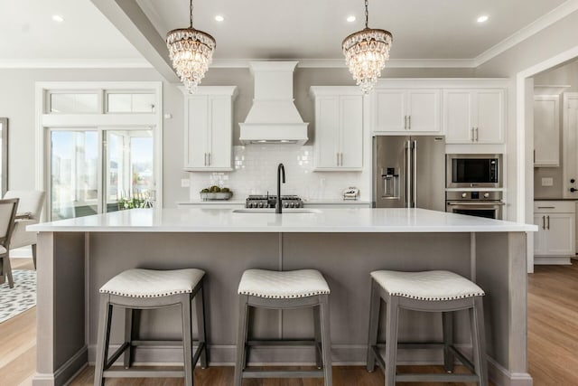 kitchen with stainless steel appliances, tasteful backsplash, a chandelier, and custom range hood