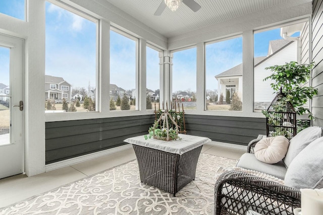 sunroom with plenty of natural light, a residential view, and ceiling fan