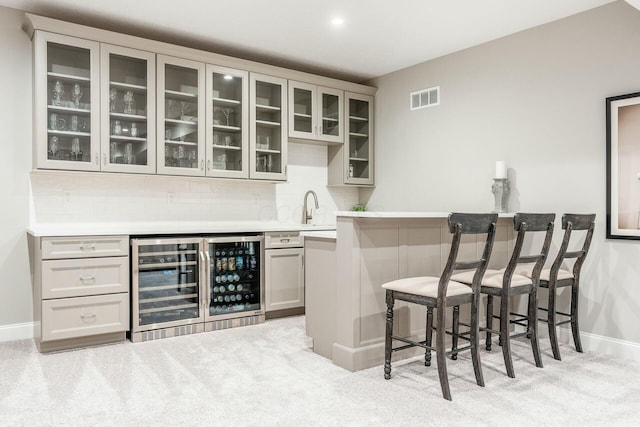 bar featuring wet bar, tasteful backsplash, beverage cooler, and visible vents