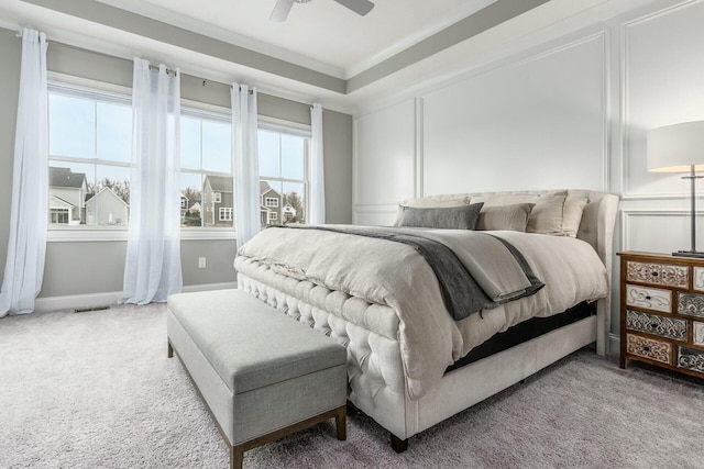 carpeted bedroom featuring baseboards, multiple windows, ornamental molding, and a ceiling fan