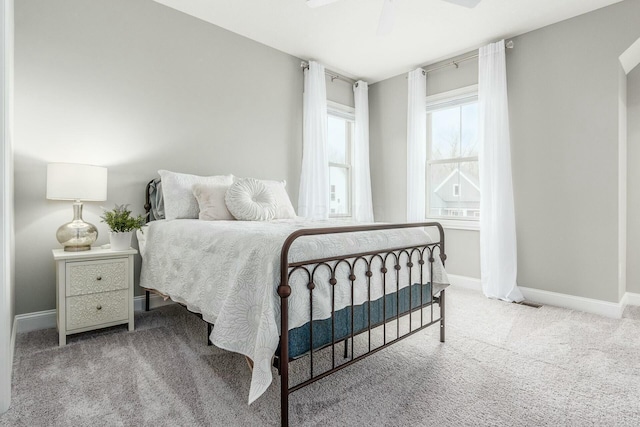 bedroom with a ceiling fan, baseboards, and carpet floors