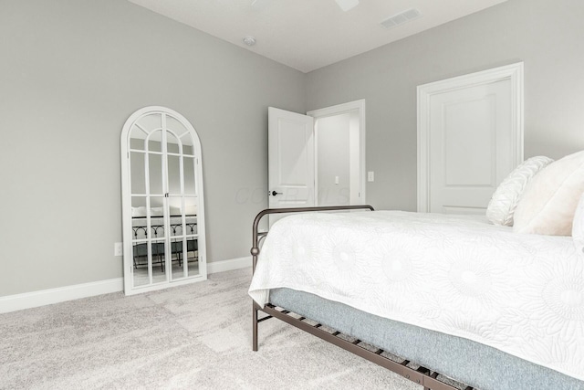 carpeted bedroom with visible vents, baseboards, and ceiling fan